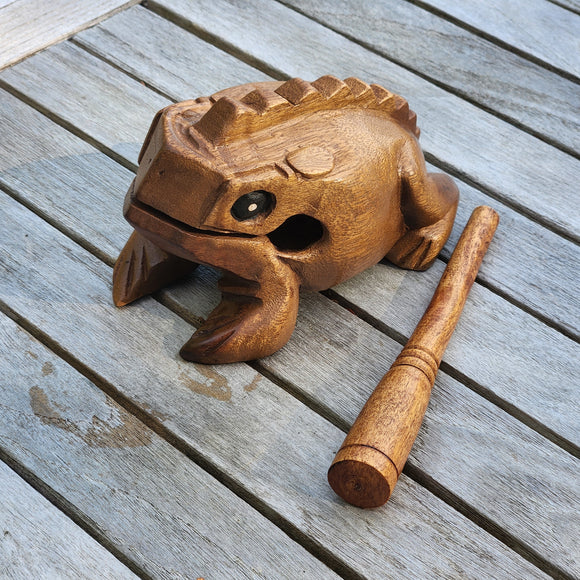 Wooden frog-shaped percussion instrument on a wooden surface