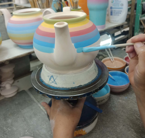 fair trade rainbow teapot being handpainted