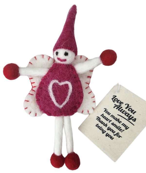 A felted wool fairy doll with a magenta body, white wings, and magenta pom-pom accents, shown with a cream gift tag that reads 'Love You Always. You make my heart smile! Thank you for being you'.
