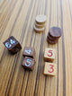 Close up of wooden backgammon pieces and dice. Doubling dice, and light and dark playing dice pairs