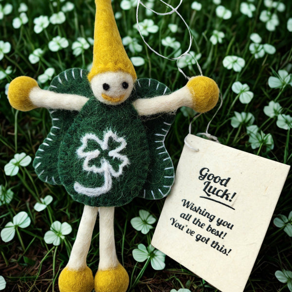 A felt St. Patrick's Day fairy to give you the 'luck of the Irish'? This keepsake has a yellow hat and shoes, green body and wings, and a white shamrock design, hanging outdoors among clover with a 'Good Luck' message/gift tag.