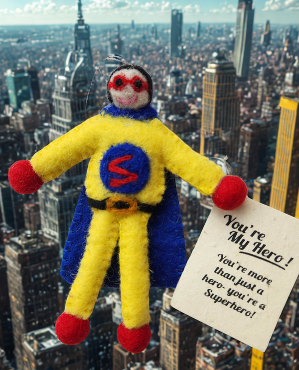 A handmade felt superhero character pictured flying about a city landscape