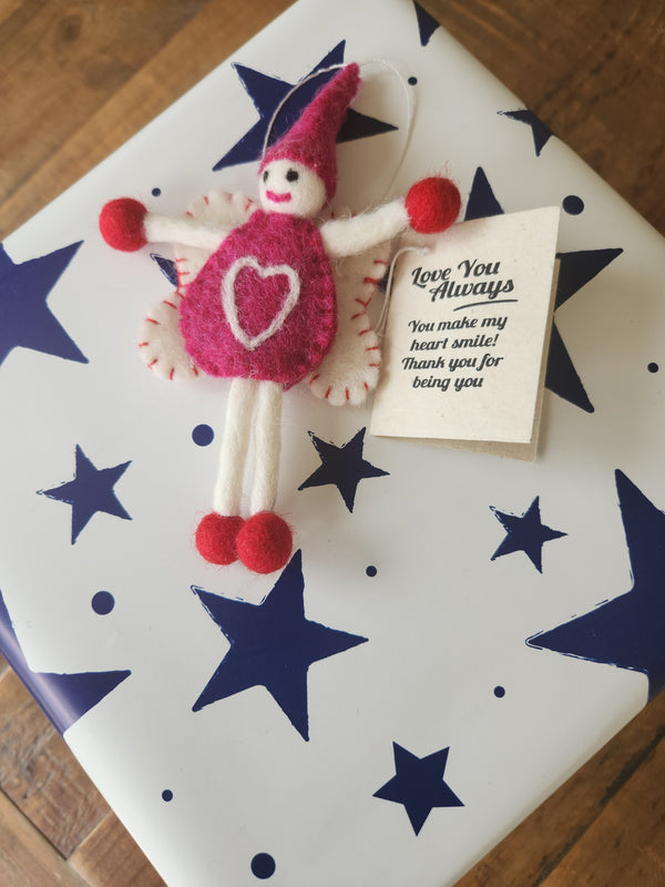 A handmade felt gift tag, displayed on top of a wrapped gift box with navy blue stars. A small gift tag card next to it reads, 'Love You Always You make my heart smile! Thank you for being you'.