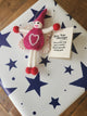A handmade felt gift tag, displayed on top of a wrapped gift box with navy blue stars. A small gift tag card next to it reads, 'Love You Always You make my heart smile! Thank you for being you'.