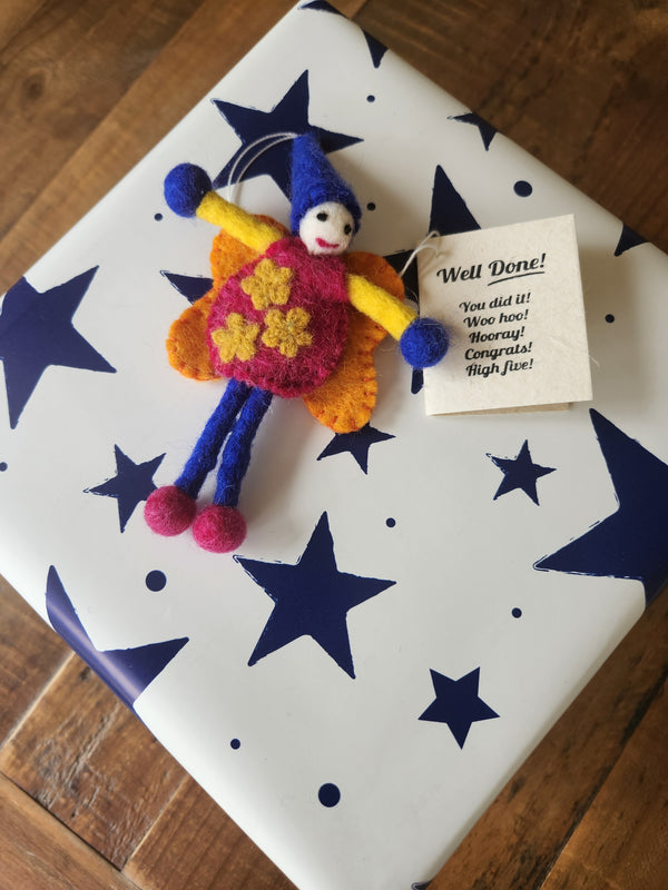 A felt fairy/pixie gift tag shown attached to a present with the "Well Done" gift message.