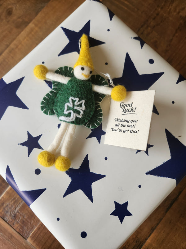 A 'Good Luck' gift tag and keepsake fairy attached to a present.
