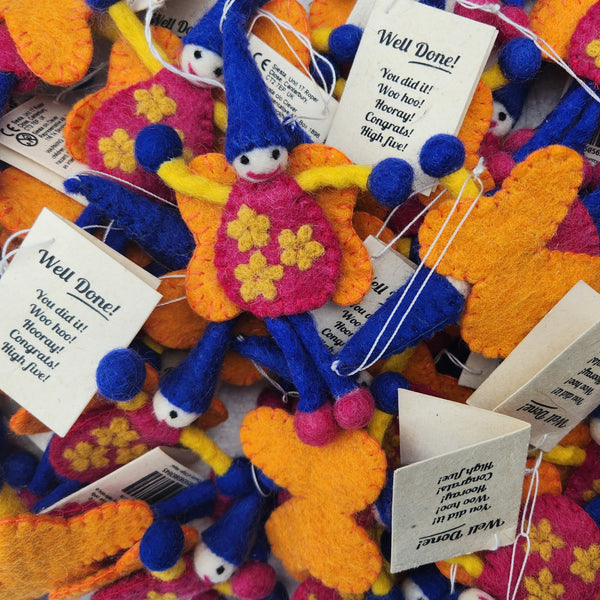 A close-up of multiple 'Well Done' fairies/pixies keepsakes