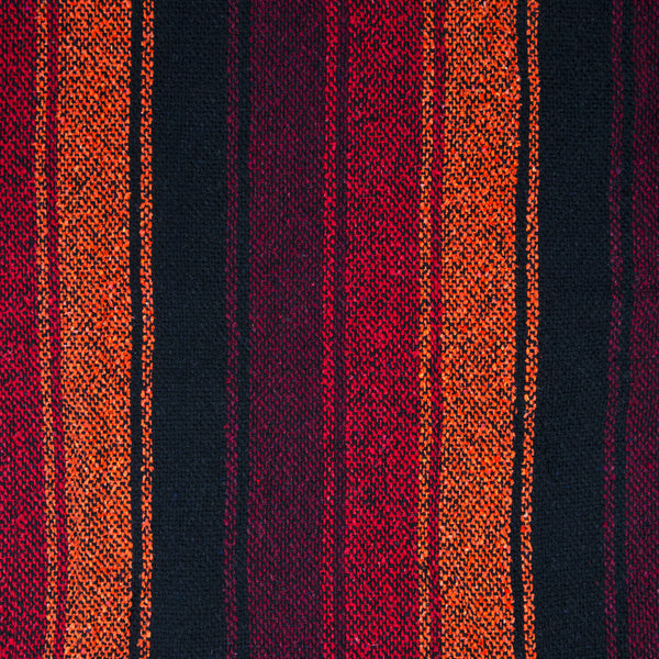Close-up of a fabric swatch from mexican baja hoody with shades of red, orange  and black striped pattern