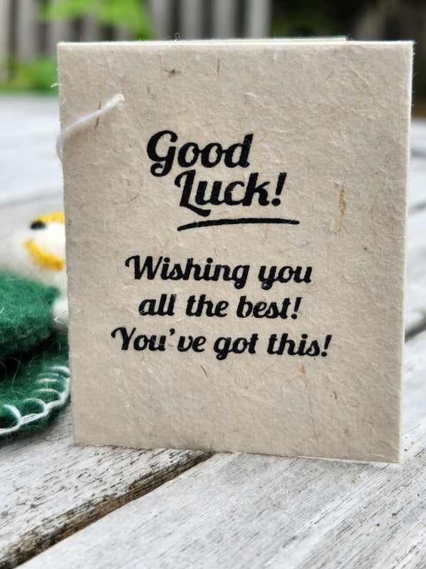 A handmade gift tag made from natural beige paper with black printed text reading 'Good Luck! Wishing you all the best! You've got this!'