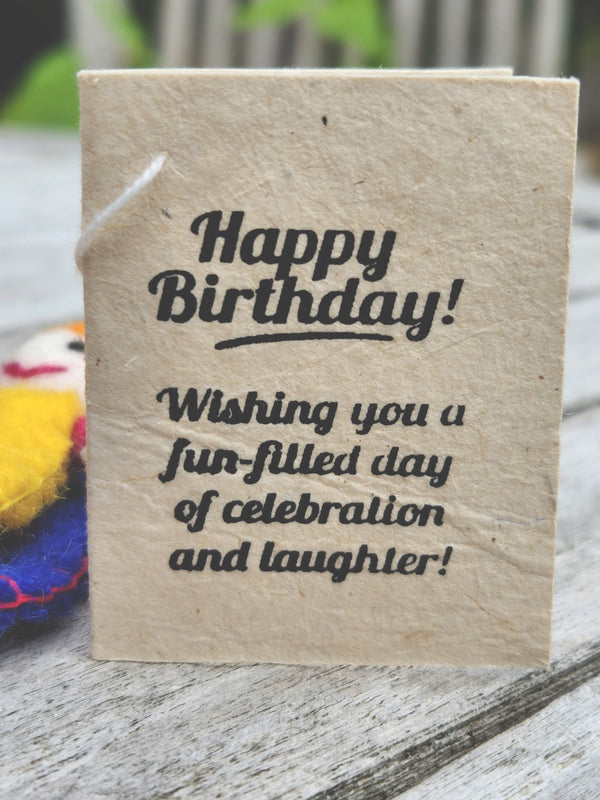 A small handmade gift tag made from natural beige paper with black printed text reading 'Happy Birthday! Wishing you a fun-filled day of celebration and laughter!' 